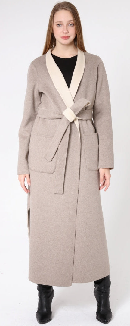 Woman wearing a long beige coat with a white collar on a white background