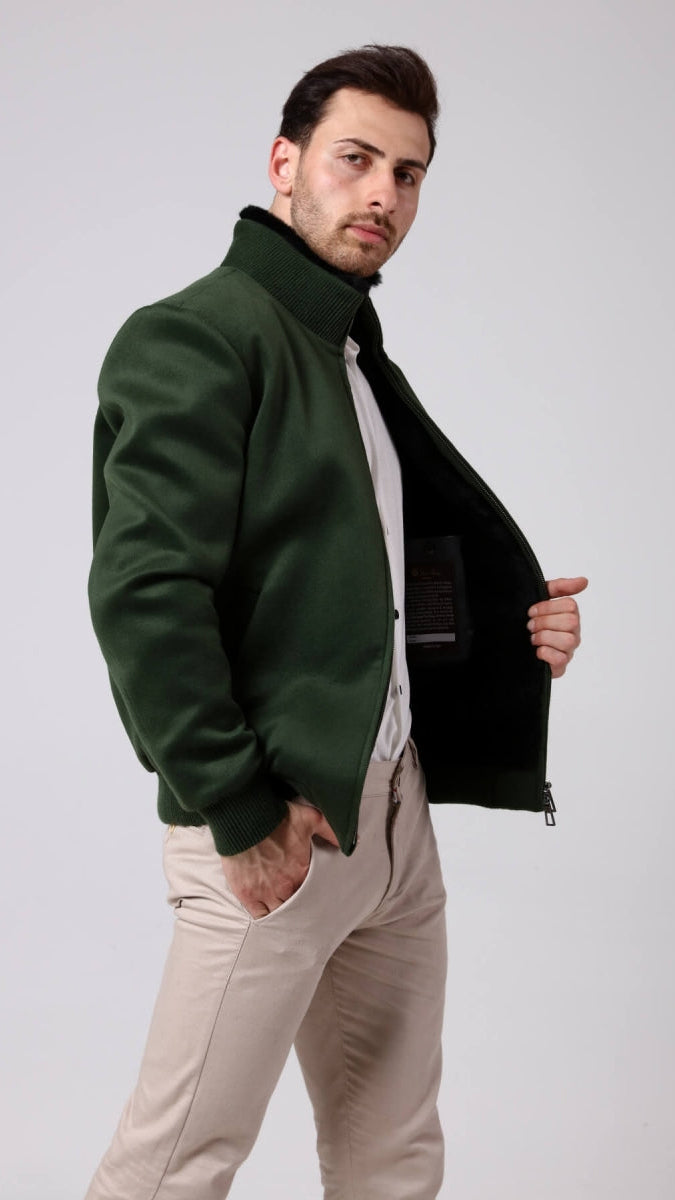 Man wearing a green jacket with a black lining, standing against a plain background