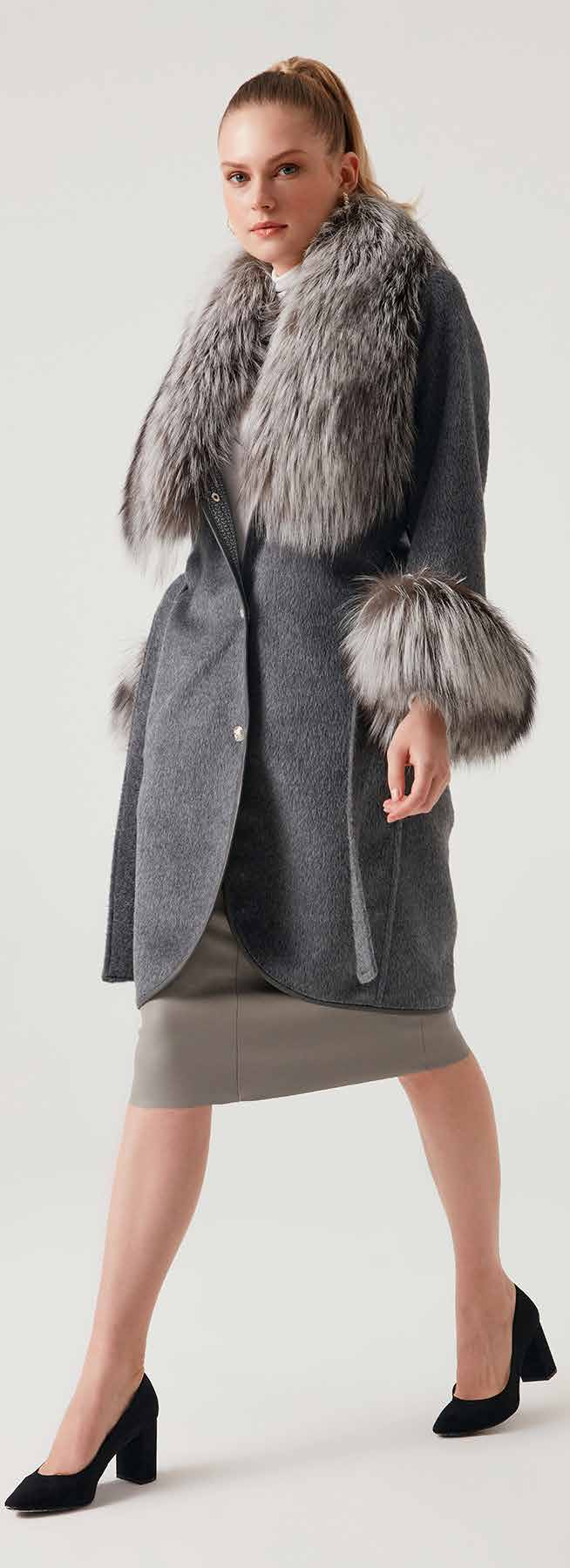 Woman wearing a gray coat with fur trim on a white background