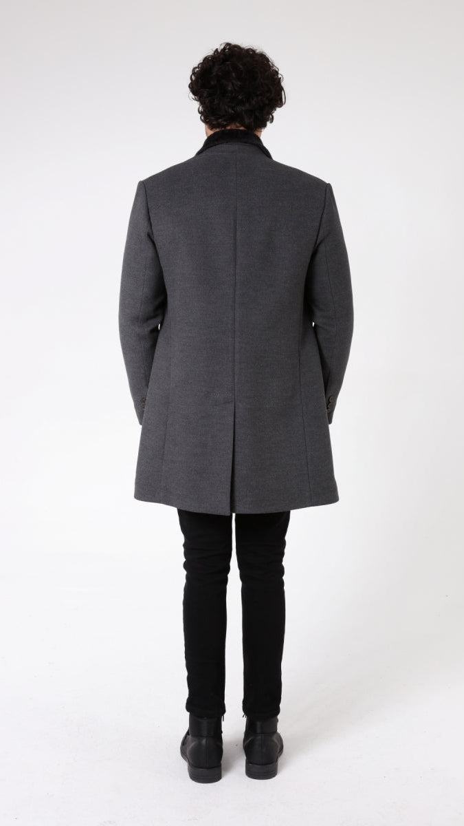 Man wearing a gray coat on a white background