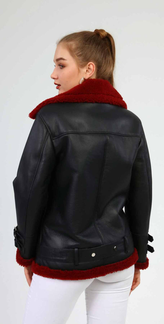 Black leather jacket with red fur trim worn by a person on a white background
