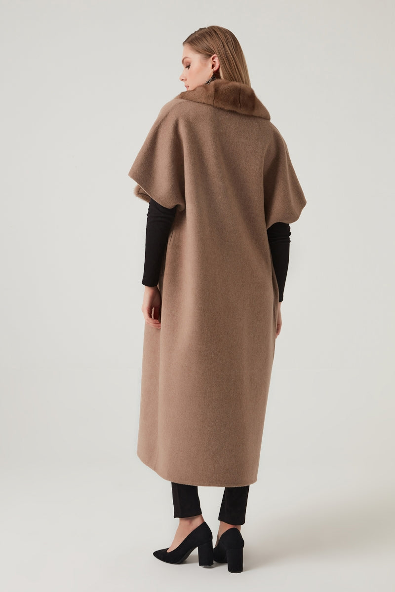 Woman wearing a long brown coat on a white background