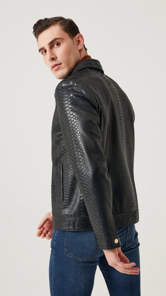 Man wearing a black textured jacket and blue jeans on a light gray background