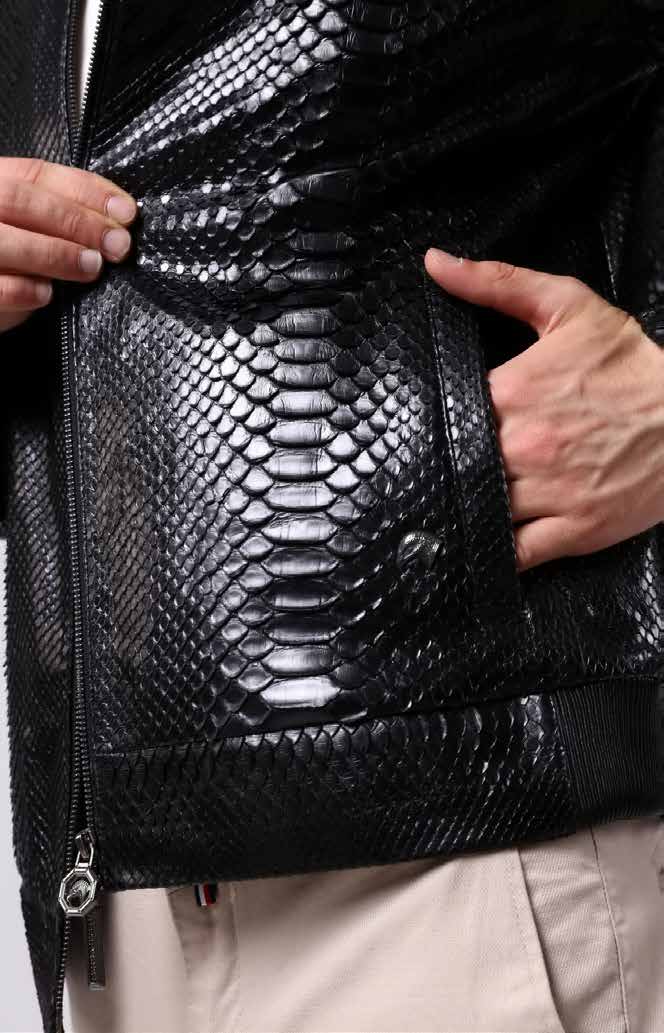 Close-up of a person wearing a black leather jacket with snake skin pattern.