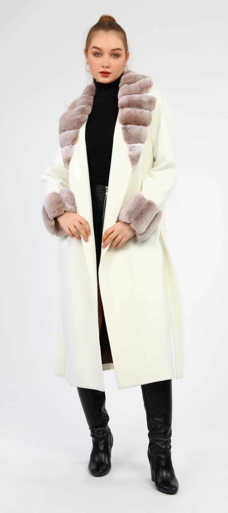 Woman wearing a long cream coat with fur trim on a white background