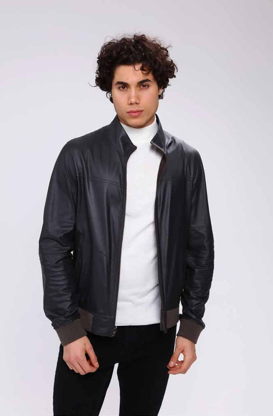 Man wearing a black leather jacket over a white shirt on a white background