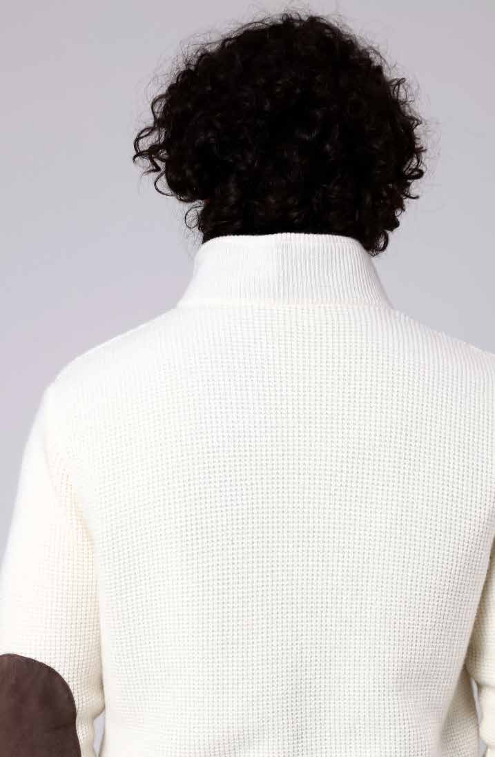 Man wearing a white sweater with a plain background