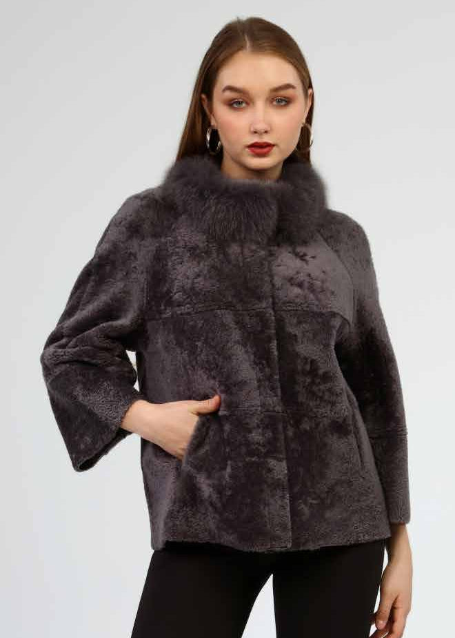 Woman wearing a dark gray fur coat, black leggings, and black knee-high boots on a white background