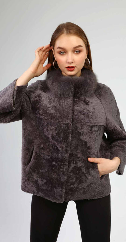 Woman wearing a gray textured coat against a plain background