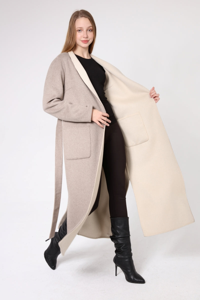 Woman wearing a long beige coat with a cream-colored lining on a white background