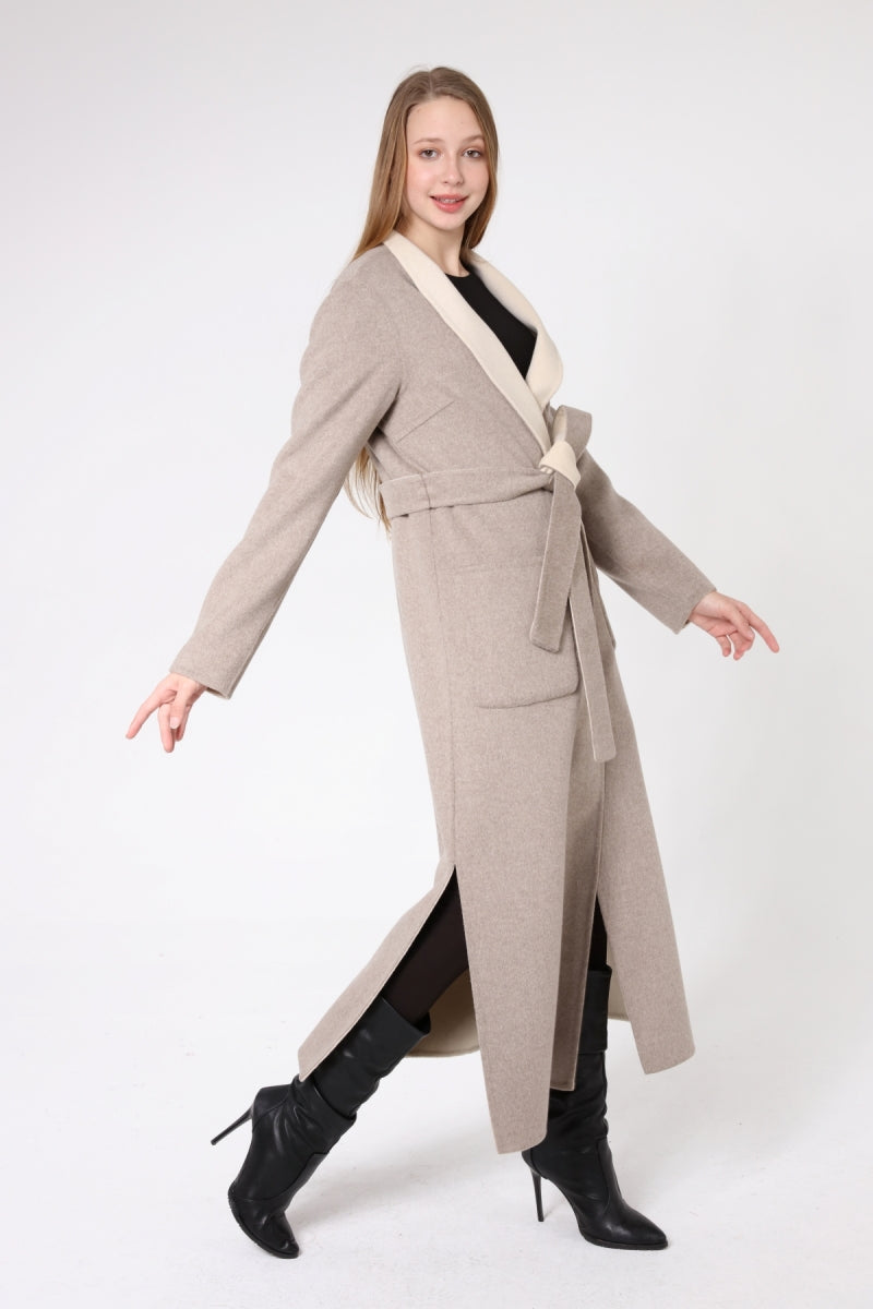 Woman wearing a long beige coat with a white collar on a white background