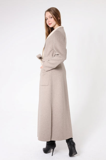 Woman wearing a long beige coat on a white background