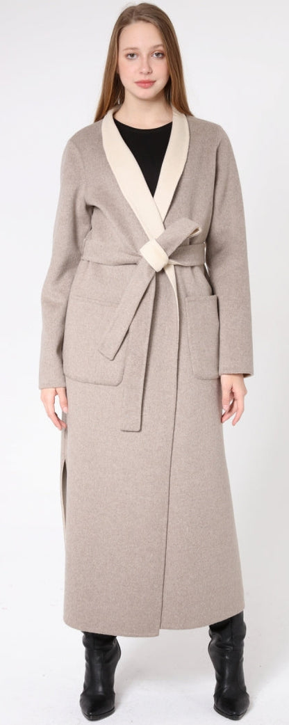 Woman wearing a long beige coat with a white collar on a white background