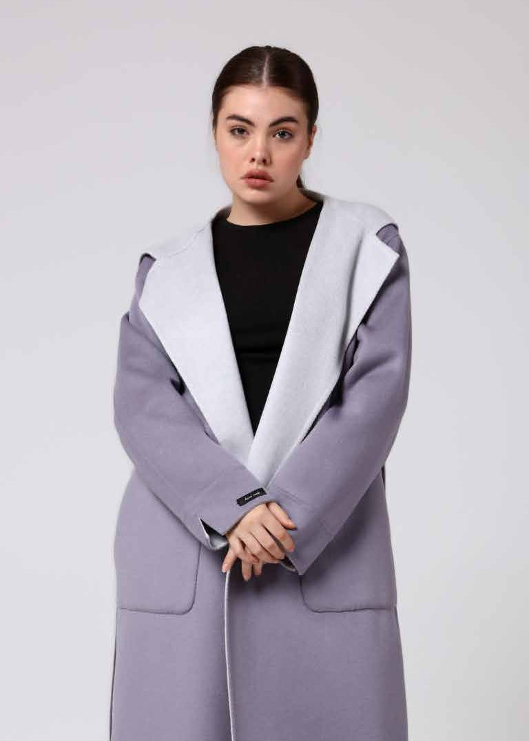 Woman wearing a long gray alpaca overcoat on a white background