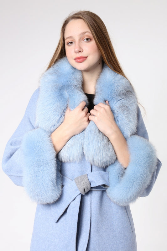 Woman wearing a light blue coat with fur trim on a white background