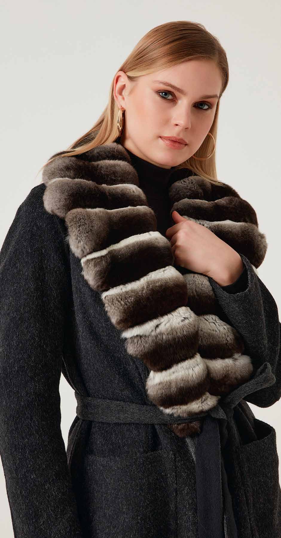 Woman wearing a long fur scarf with a plain background