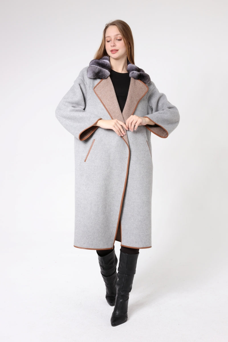 Woman wearing a gray coat with fur trim on a white background