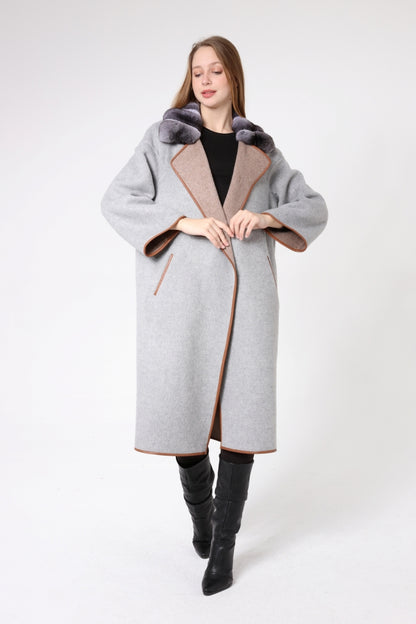 Woman wearing a gray coat with fur trim on a white background