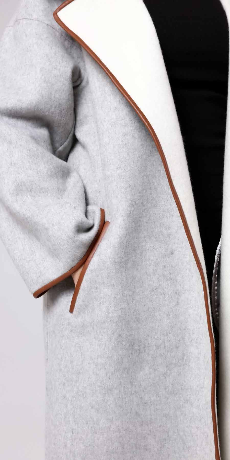 Close-up of a gray coat with brown trim on a black background