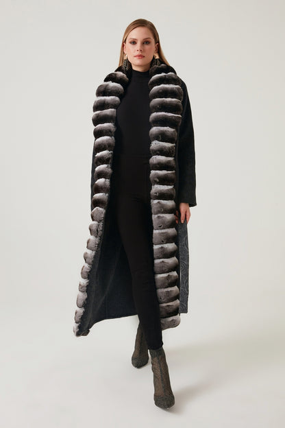 Woman wearing a long fur coat with a white background