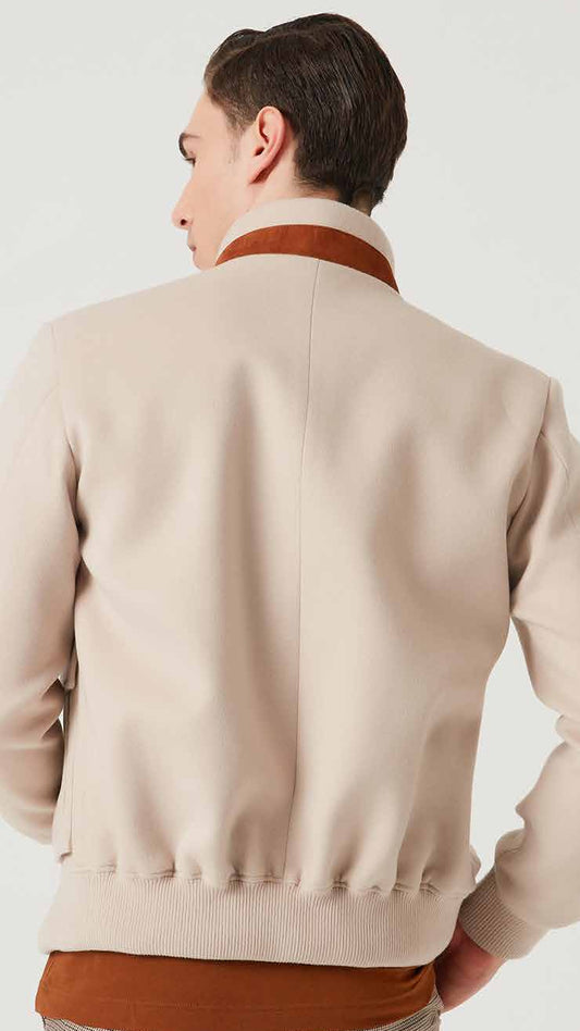 Man wearing a beige jacket with a brown collar and trim on a white background