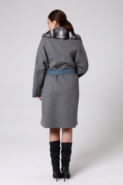 Woman wearing a gray coat with a belt on a white background