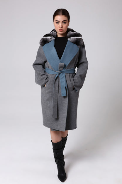 Woman wearing a gray coat with a blue inner lining on a white background