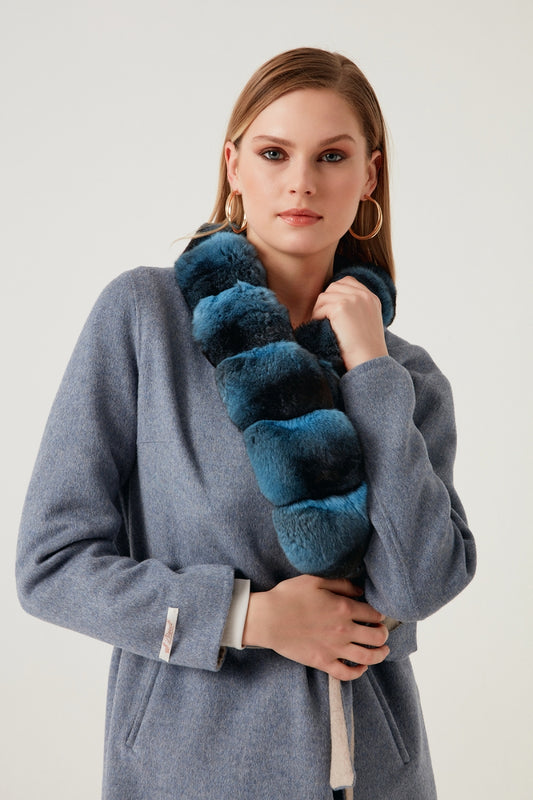 Woman holding a blue fur stole against a white background