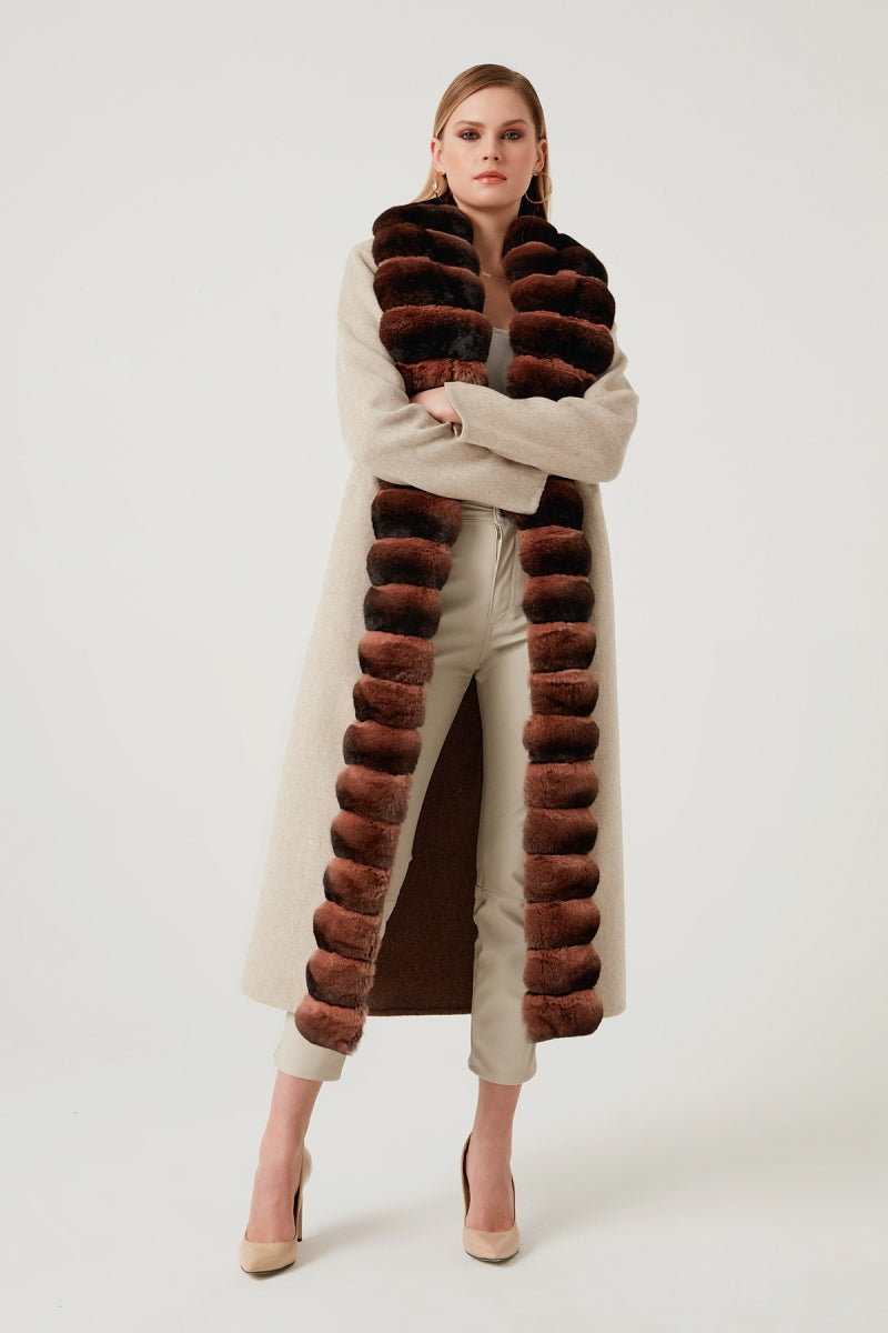 Woman wearing a long fur vest with a white background