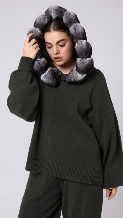 Woman wearing a khaki sweater with a unique chinchilla design on a light gray background