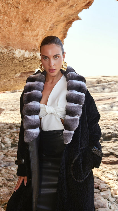 Woman wearing a stylish outfit with a fur coat in a rocky outdoor setting