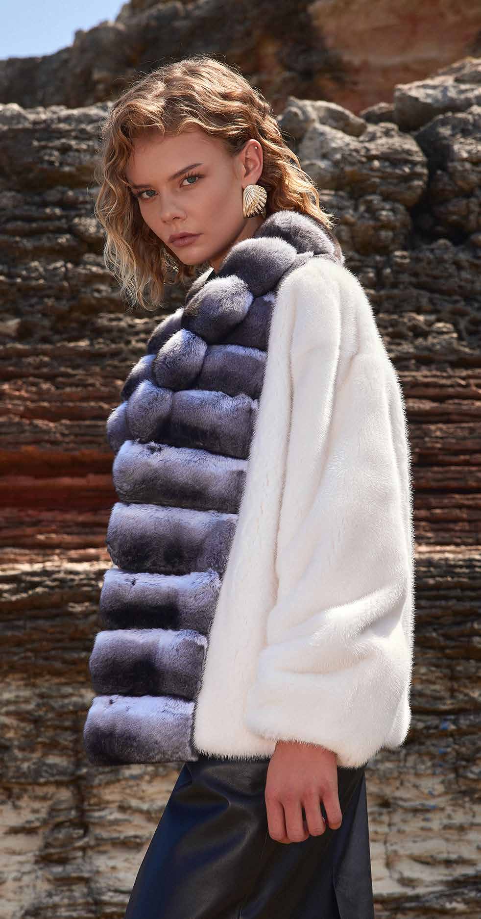Woman wearing a layered fur vest against a natural background