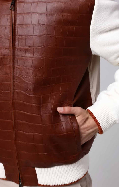 Brown leather vest worn by a person with a white sweater underneath, on a plain background.