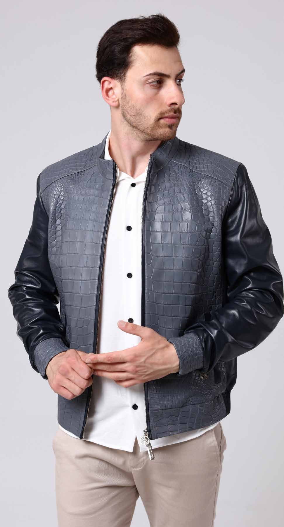 Man wearing a dark gray textured leather jacket over a white shirt on a light gray background