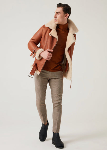 Man wearing a brown shearling jacket with a white background