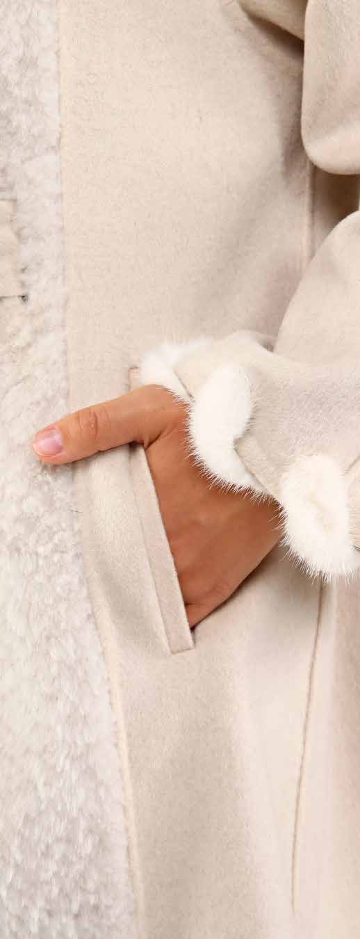 Close-up of a beige coat with white fox fur trim on a textured background