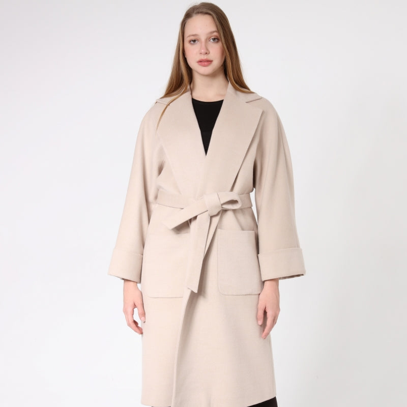 Woman wearing a beige cashmere coat with a white background