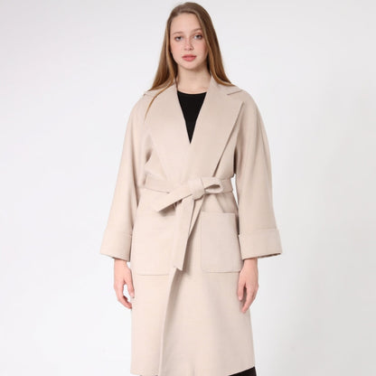 Woman wearing a beige cashmere coat with a white background