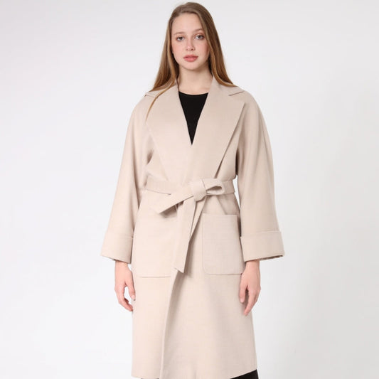 Woman wearing a beige cashmere coat with a white background