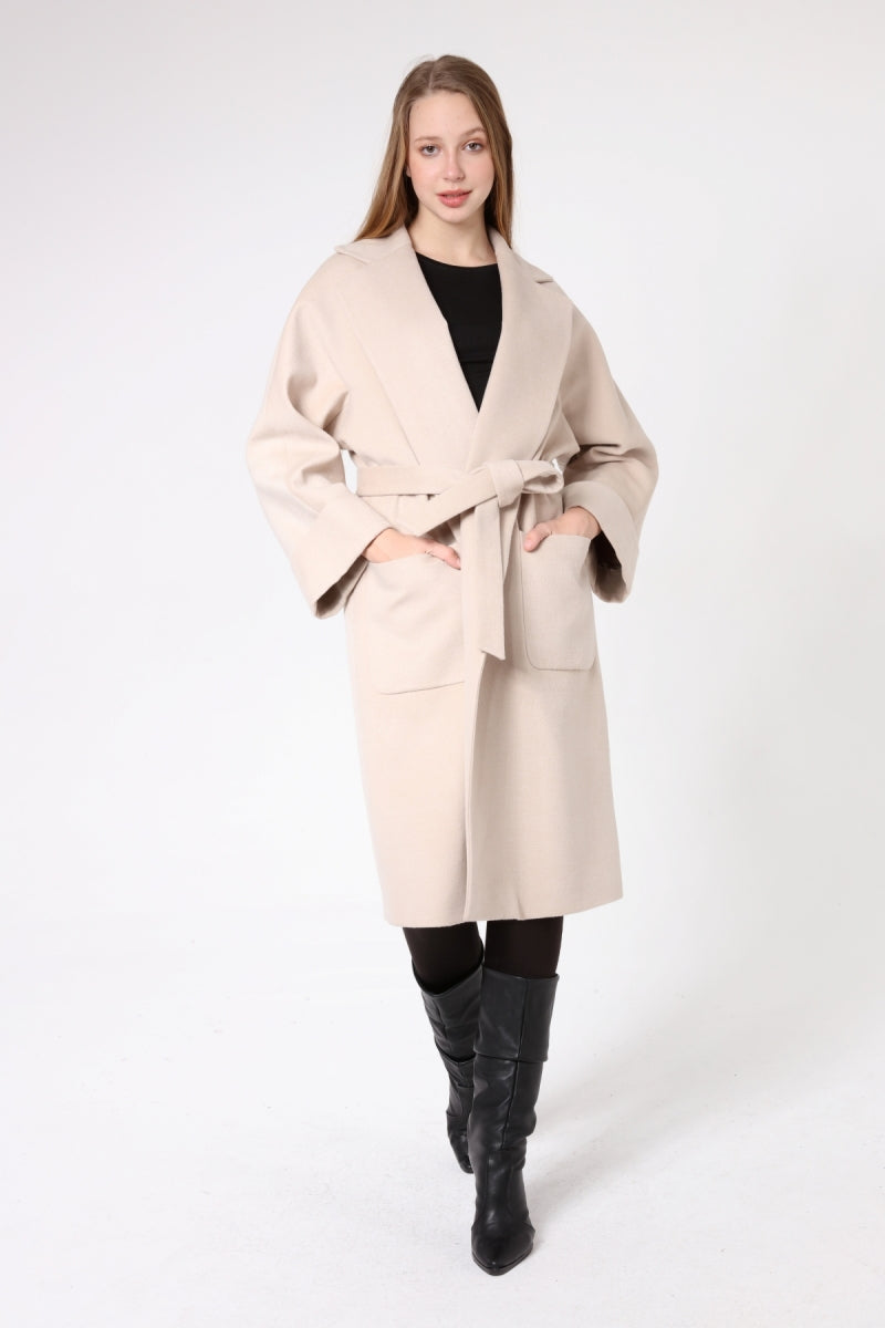 Woman wearing a beige coat on a white background
