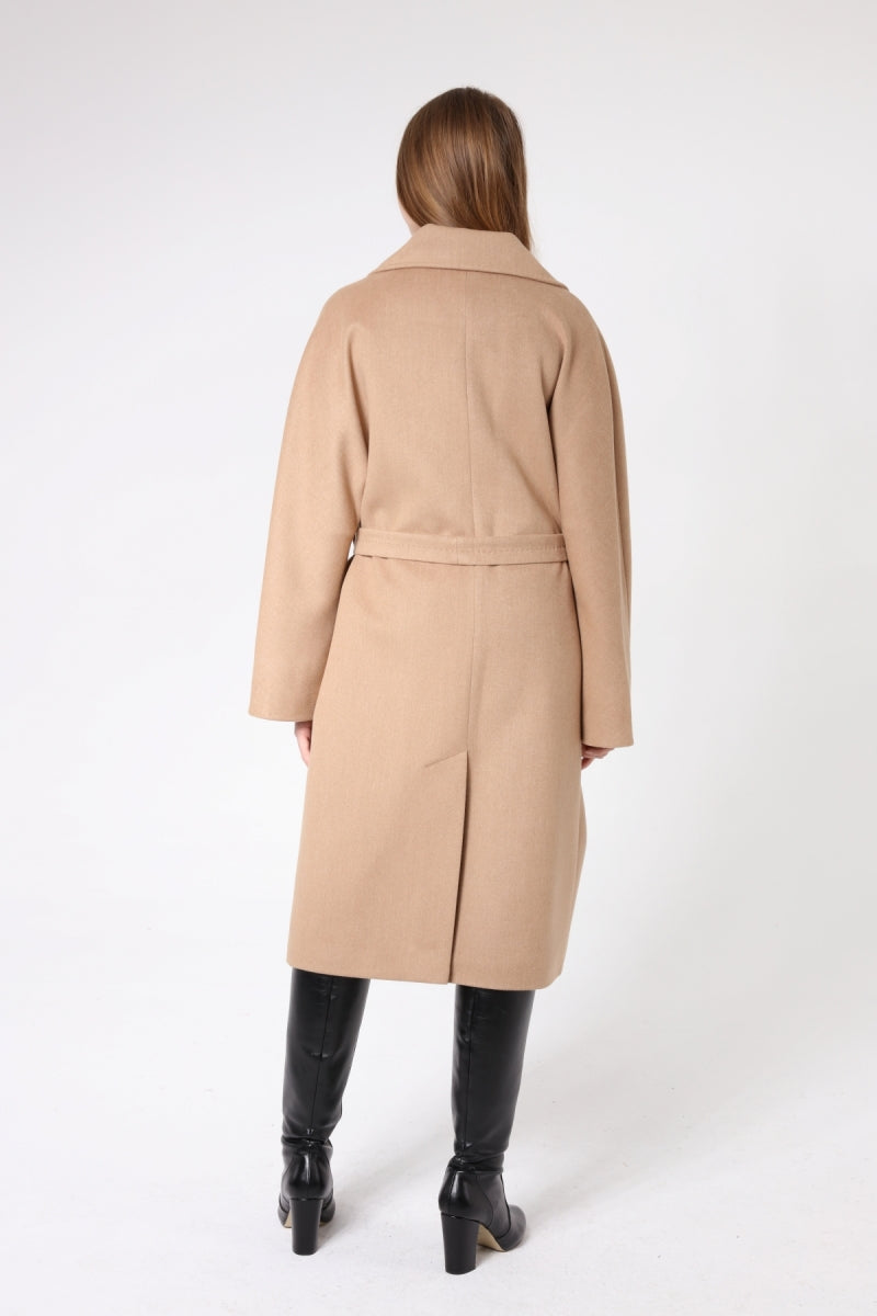 Woman wearing a beige coat on a white background