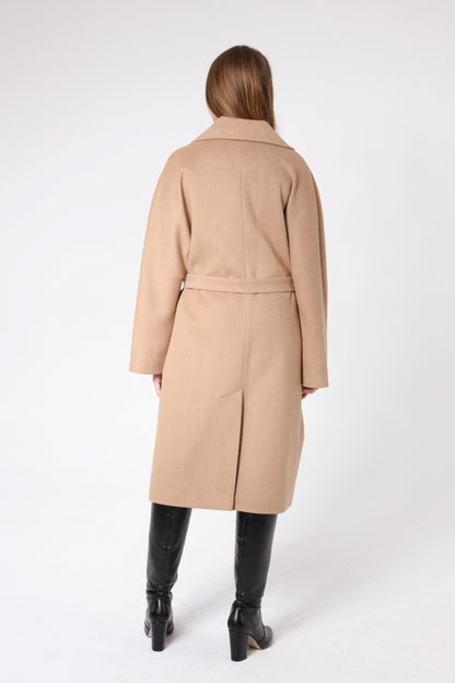 Woman wearing a beige coat on a white background