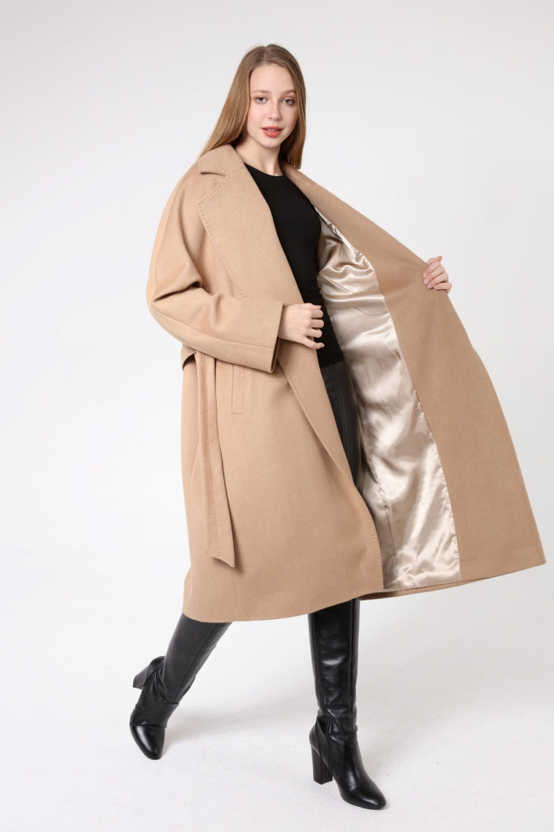 Woman wearing a beige coat with a satin lining on a white background