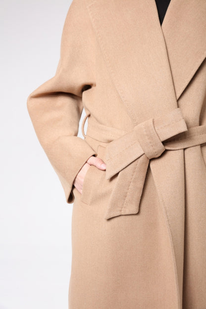 Close-up of a beige trench coat with a belt on a light gray background