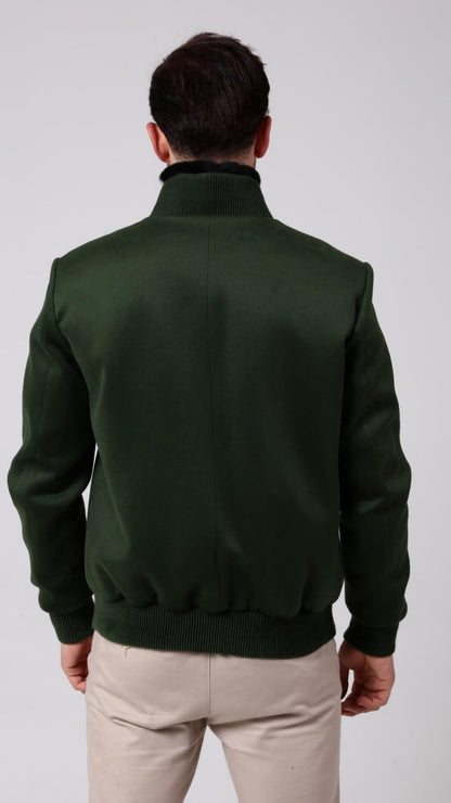 Man wearing a green jacket and beige pants on a white background