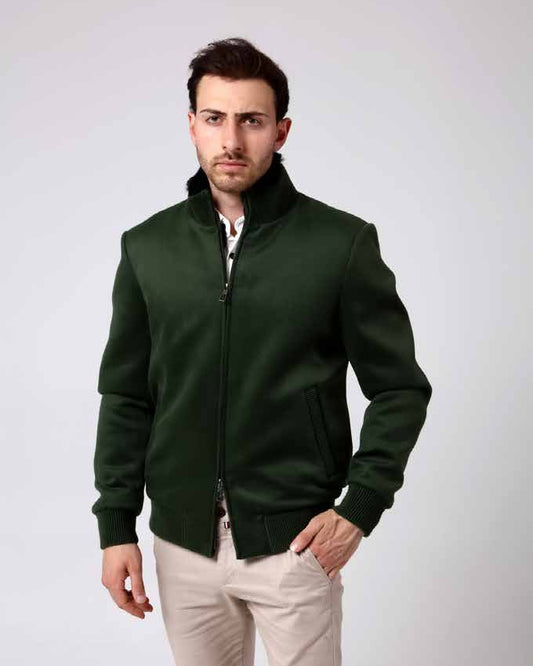 Man wearing a green jacket and light-colored pants on a white background
