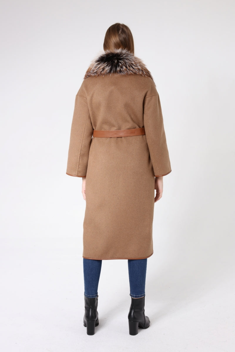 Woman wearing a tan coat with fur collar on a white background