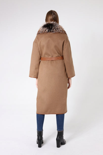 Woman wearing a tan coat with fur collar on a white background