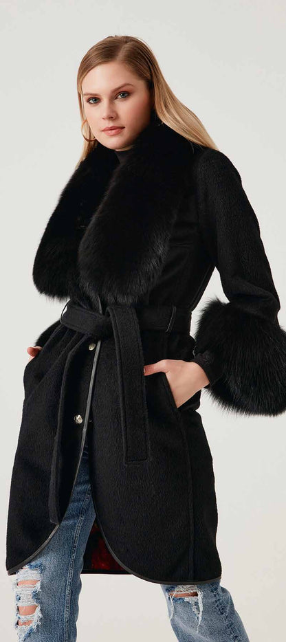 Woman wearing a black coat with fur trim on a white background