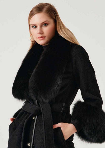 Woman wearing a black coat with fur trim on a white background